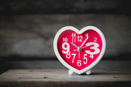 vintage heart clock on wooden backgroundの写真素材