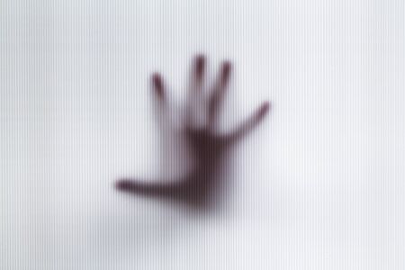 Abstract blur hands silhouettes behind glass foreground