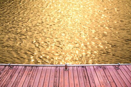 Wood plank for walk with sun light water surface waves backgroundの写真素材