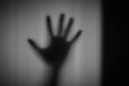 Abstract blur hands silhouettes behind glass foregroundの写真素材