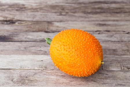 Gac,Baby Jackfruit Spiny Bitter Gourd, Sweet Gourd.A Southeast Asian fruit isolate on wooden table background.の写真素材
