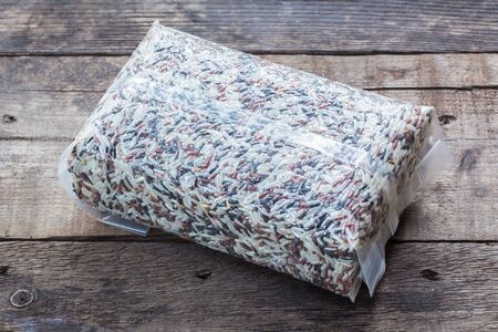 a bag of brown rice isolated on a wooden backgroundの写真素材