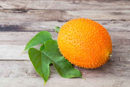 Gac,Baby Jackfruit Spiny Bitter Gourd, Sweet Gourd.A Southeast Asian fruit isolate on wooden table background.の写真素材
