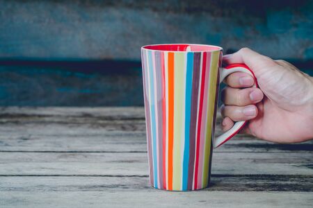 vintage soft tone with hand hold colorful mug.の写真素材