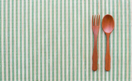 empty white plate and wooden spoon on bamboo mat.の写真素材