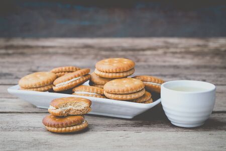 vintage soft tone of cookies bread and a Teacup on wooden table. Menu set for afternoon snack.の写真素材