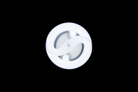 Energy saving fluorescent light bulb, isolated black backgroundの写真素材