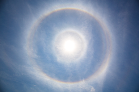 fantastic beautiful sun double ring halo phenomenon in thin cirrus clouds in the atmosphere. in Thailandの写真素材