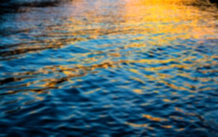 abstract blur background of dark blue sea water surface with sunset.の写真素材