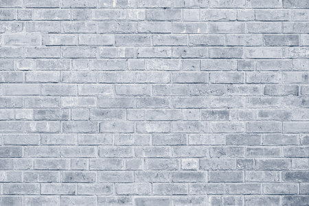 Old stucco light gray and aged paint white brick wall backgroundの写真素材