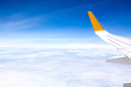 Wing of an airplane flying above the oceanの写真素材
