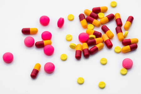Assorted pharmaceutical medicine and colour capsules on white background. Copy space for add text message.の写真素材