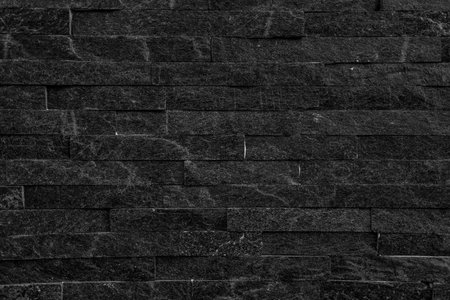Black stone wall background. old stucco black and aged paint brick wall background design.の写真素材