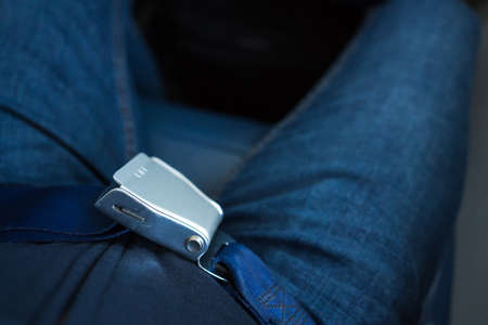 A belt on a plane for safety while driving. Person adjust waist belt for plane to take off or landing.の写真素材
