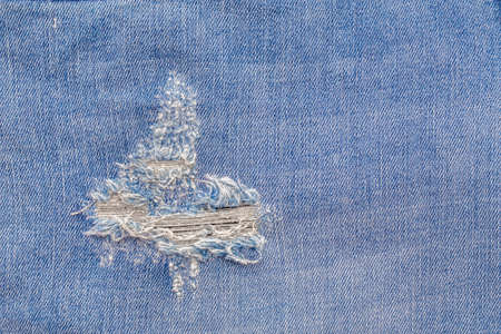 Abstract Jeans with torn marks. Retro colour tone of blue denim jeans fabric texture for background website fashion design or backdrop product.の写真素材