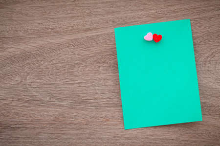 Abstract empty sticky note with heart on wood table. valentine greeting card message.の写真素材