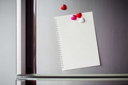 Abstract of wooden heart clip with Blank paper and stick paper on refrigerator door. paper note copy space for add text. valentine picture message backgroundの写真素材