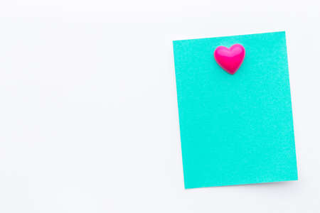 Abstract empty sticky note with heart magnet on white board. valentine greeting card message.