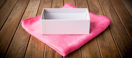 open gift box on pink fabric  on wooden table.