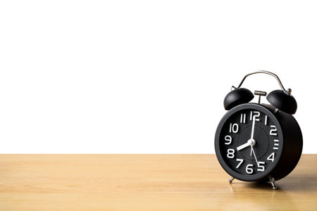 Black alarm clock retro style on wooden floor table. concept watch for add text message or art work design. pointer in 8 o'clock.の写真素材