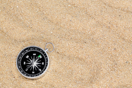 Compass in the sea sand on beach background with copy space for add text message or use components for design. Summer Travel destination and Navigation Concept Backdrop.の写真素材