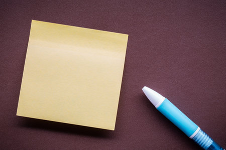 paper note and pen on brown leather pad background with copy space.の写真素材