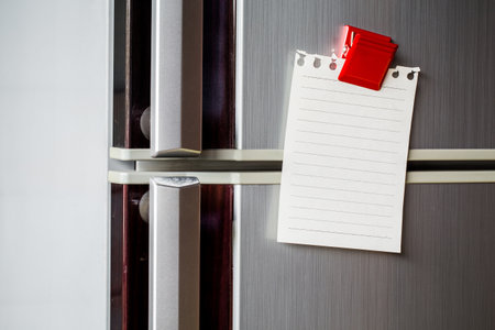 Empty paper sheet on refrigerator door with magnetic clip paper note for add text message.の写真素材