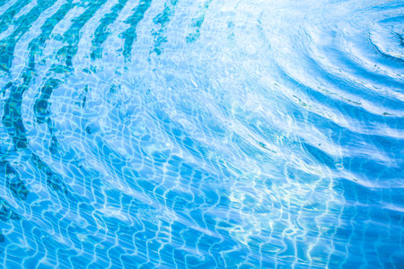 Texture water wave in swimming pool with sunny reflections.の写真素材