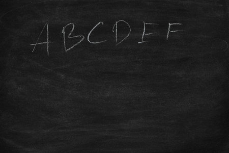Abstract hand writing English alphabet with chalk on blackboard. letters A B C to Z on a black chalkboard.の写真素材
