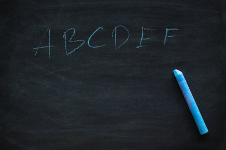 Abstract hand writing English alphabet with chalk on blackboard. letters A B C to Z on a black chalkboard.の写真素材