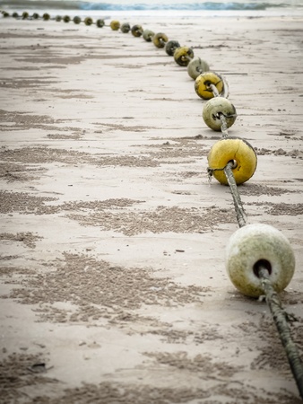 Old buoys with rope on the beachの写真素材