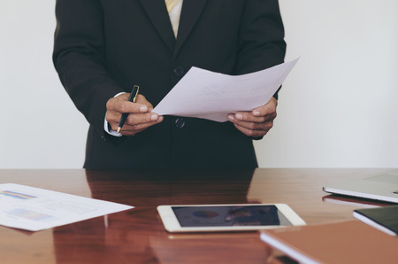 Men standing at desk and  reading document hand close up