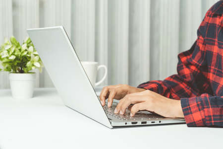 Close up. Hands typing keyboard on white laptop in office.