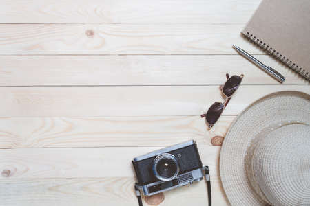 Top view travel accessories on wood texture background. Blogger journey with camera film, hat, sunglasses in summer concept.の写真素材