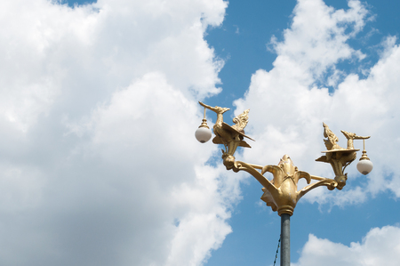 Thai style golden lamp statue and skyの写真素材