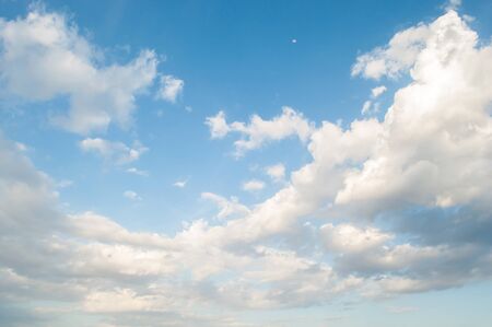 Blue sky with clouds and a little moonの写真素材