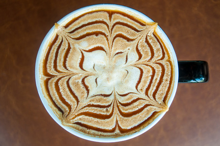 Cup of caramel latte coffee on brown sofa backgroundの写真素材