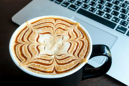 Cup of caramel latte coffee on working timeの写真素材