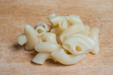 Elbow Macaroni Gomiti Pasta on chopping blockの写真素材