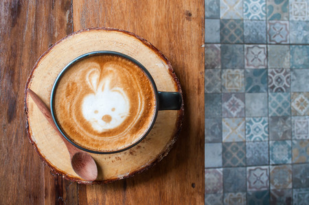 Cute Hot Latte Coffee on the wooden table over ceramic tile floorの写真素材
