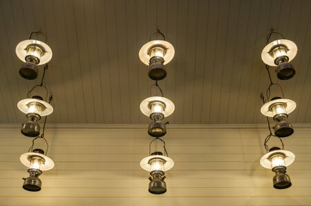 Classic Lamps lighting bulbs on a ceiling with reflectionsの写真素材