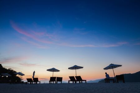 Seats and umbrella on beach under vivid colorful of sky at sunset timing  located at south of  Thailandの写真素材