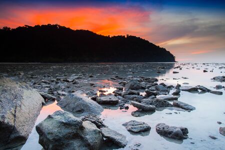 A twilight time after sunset on beach with stone foreground located south of Thailand