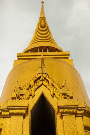 Golden pagoda of temple under clear sky at summer season location at west of thailandの写真素材