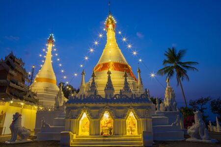 A white color of pagoda decorated by lighting at night time under clear sky located at north of Thailandの写真素材