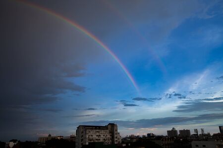 twin rainbows appear on blue sky on rainy dayの写真素材