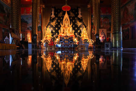 Golden buddha in temple relfect on ground location at thailandのeditorial素材