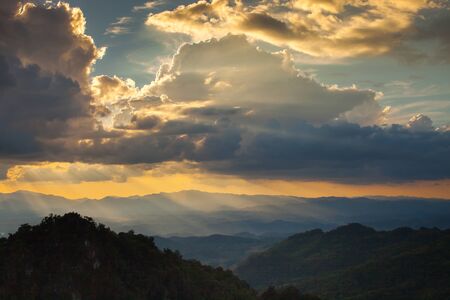 Sunset is shading to mountain behind cloudy sky located at north of Thailand