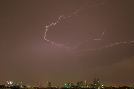 Thunder on rain cloudy sky with city view at night time located at Bangkok Thailandの写真素材