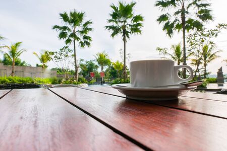 A cups of coffee on orange color wooden table backgroundの写真素材